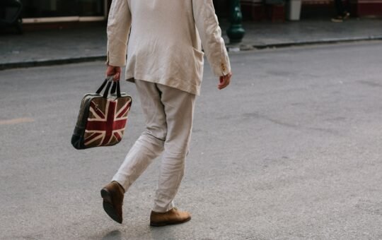 Photo of a man carrying a bag with the Union Jack flag of the UK as Prime Minister Keir Starmer unveils an AI action plan aiming to harness artificial intelligence technologies to unlock economic potential, transform public services such as the NHS, and more.